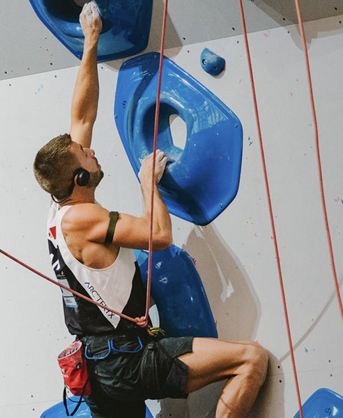 Rock climber wearing Sena EXPAND Mesh headset on indoor climbing wall - imagen 6