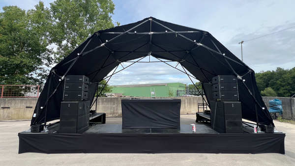 Konligo Fastival structure with black membrane cover set up outdoors on a concert stage, now available on MTN Shop US.