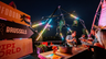 Konligo illuminated Fastival event structure with hanging plants and neon lights at rooftop bar in Brussels, creating a vibrant festival atmosphere, now available on MTN Shop US.